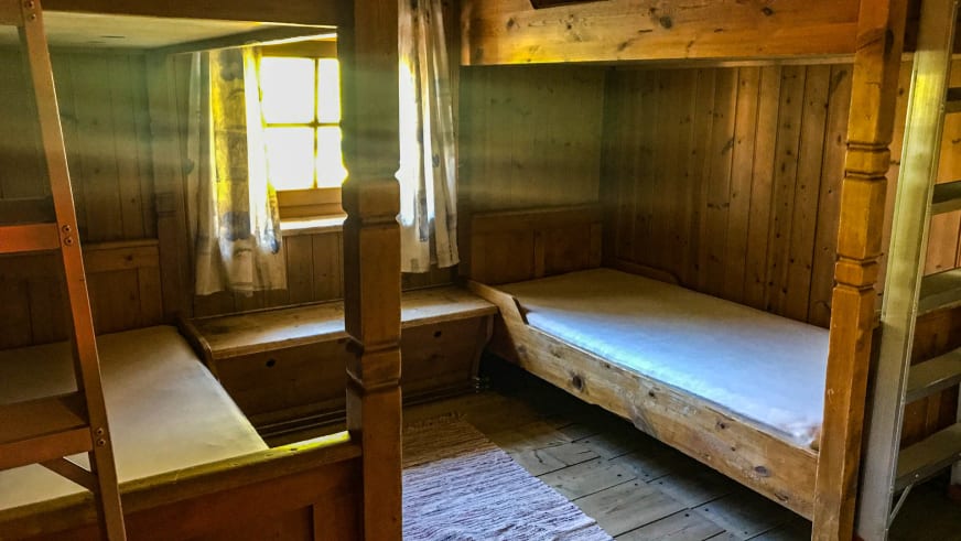 Rustikales Mehrbettzimmer im Hochjoch Hospiz mit Etagenbett und traditioneller Holzkonstruktion.
