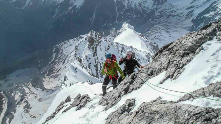 Zwei Bergsteiger am Seil beim Aufstieg über Fels und Firn nahe der Hintergrathütte im verschneiten Ortlergebiet.
