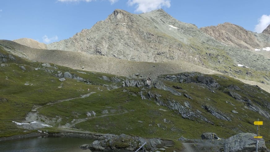 Blick über einen kleinen Bergsee zu den umliegenden Felsgipfeln bei der Sudetendeutschen Hütte.