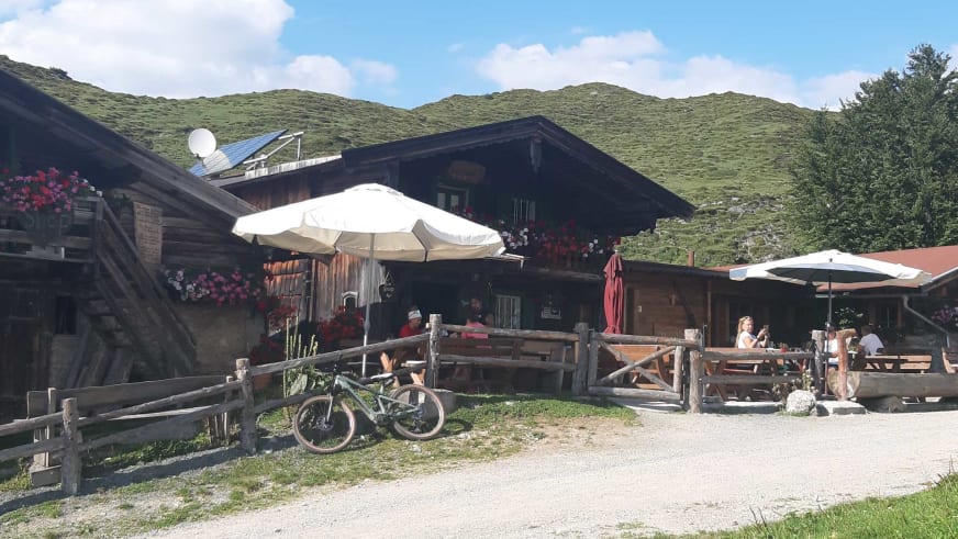 Außenansicht der Stöfflhütte mit Holzfassade, Terrasse und Mountainbike im Vordergrund.