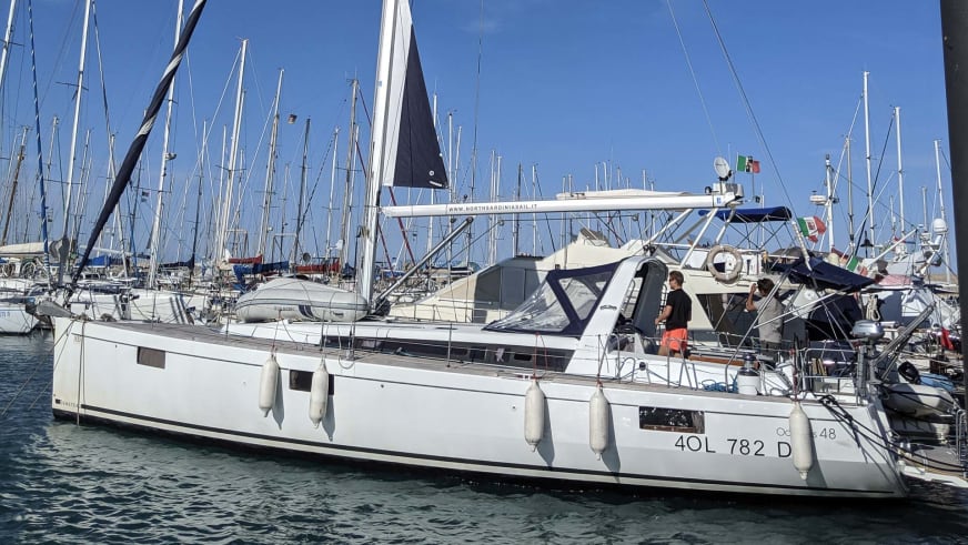Die griechische Yacht liegt als weißer Katamaran im Yachthafen von Kalymnos zwischen anderen Segelbooten.