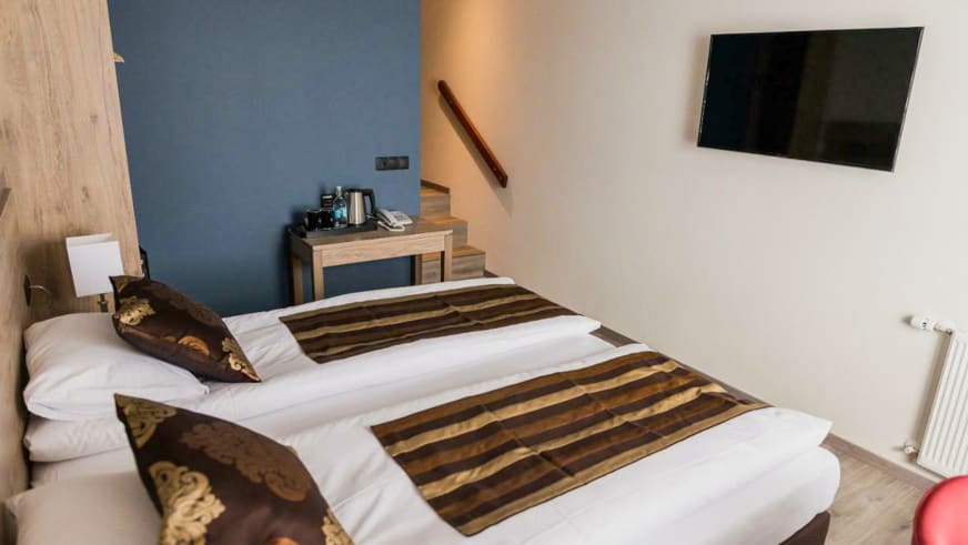 Modernes Hotelzimmer mit Doppelbett und Holztreppe im Hotel Duus by Keflavik Airport.