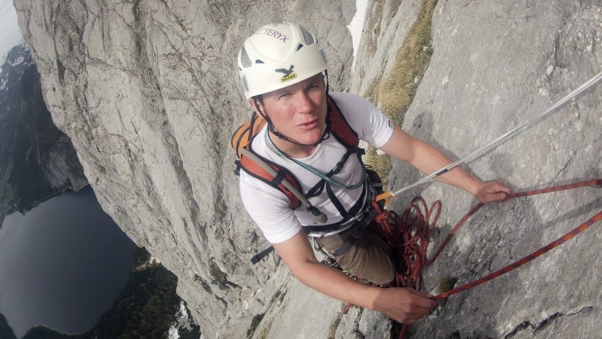 Bergführer Harald Hosner klettert an einer Felswand und zeigt seine Kletterfähigkeiten in alpinem Gelände.
