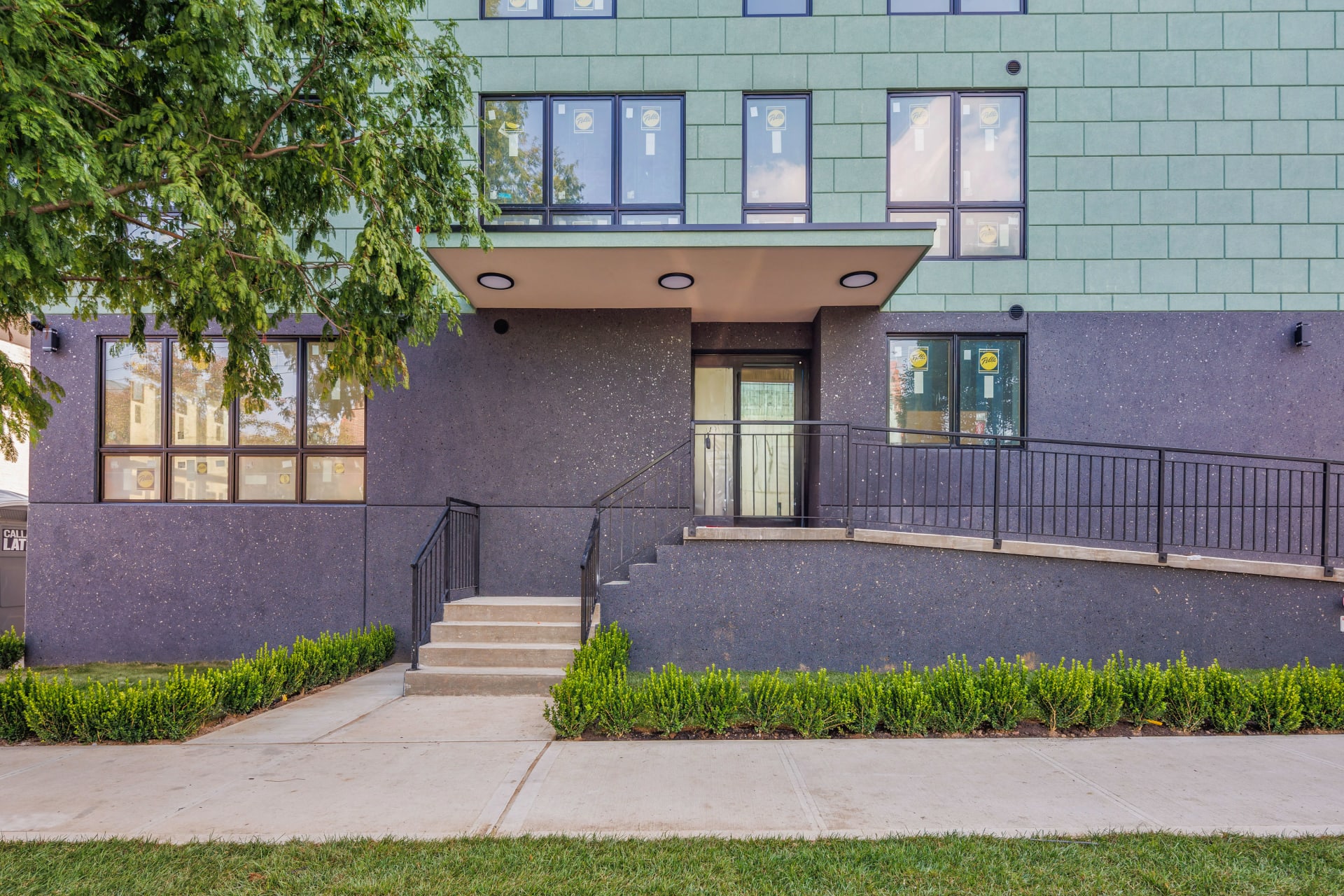 The entrance to The Dyker Reserve Condominium, with a ramp and stairs leading to the front door.