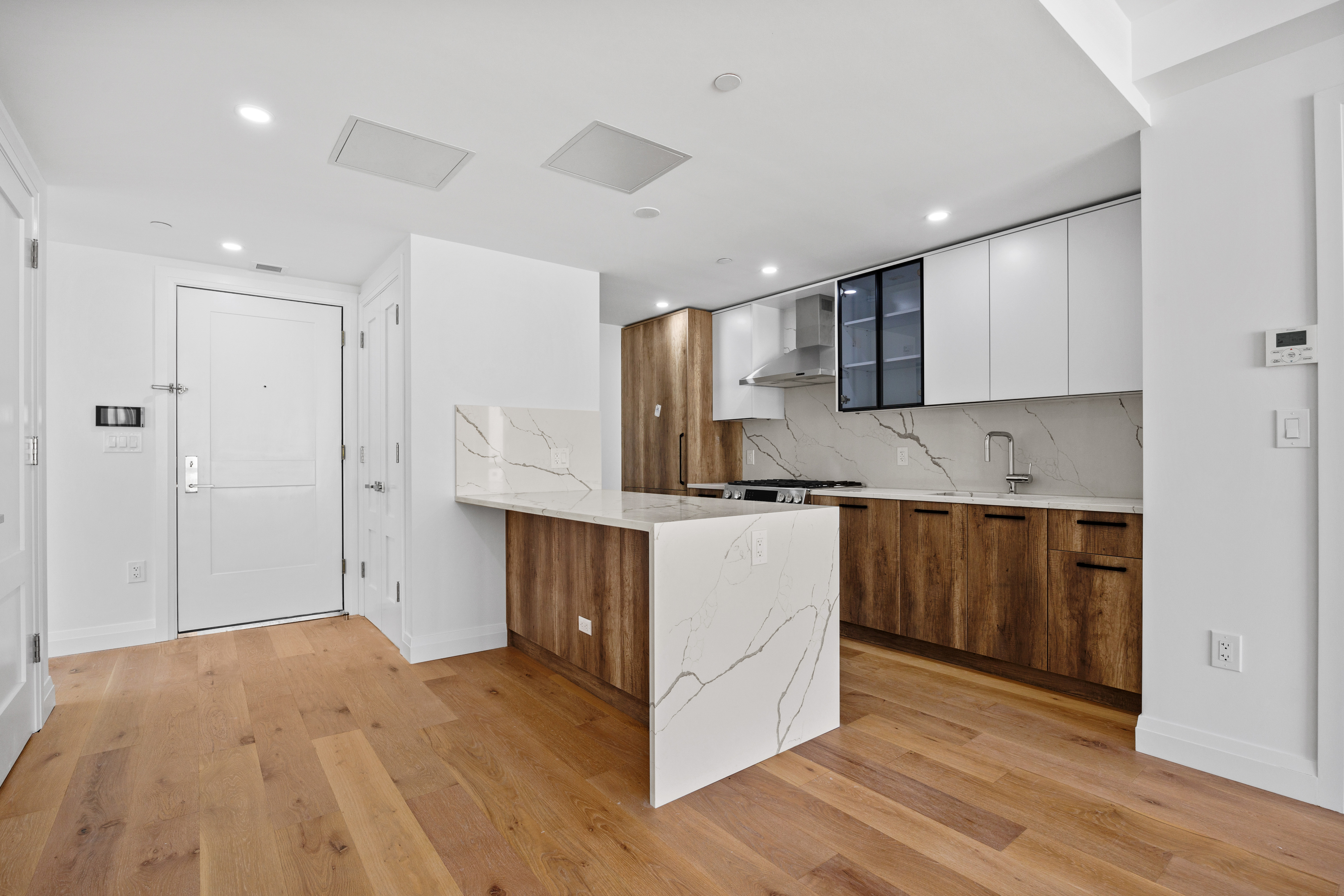 Minimalist kitchen with wood-grain and white cabinets