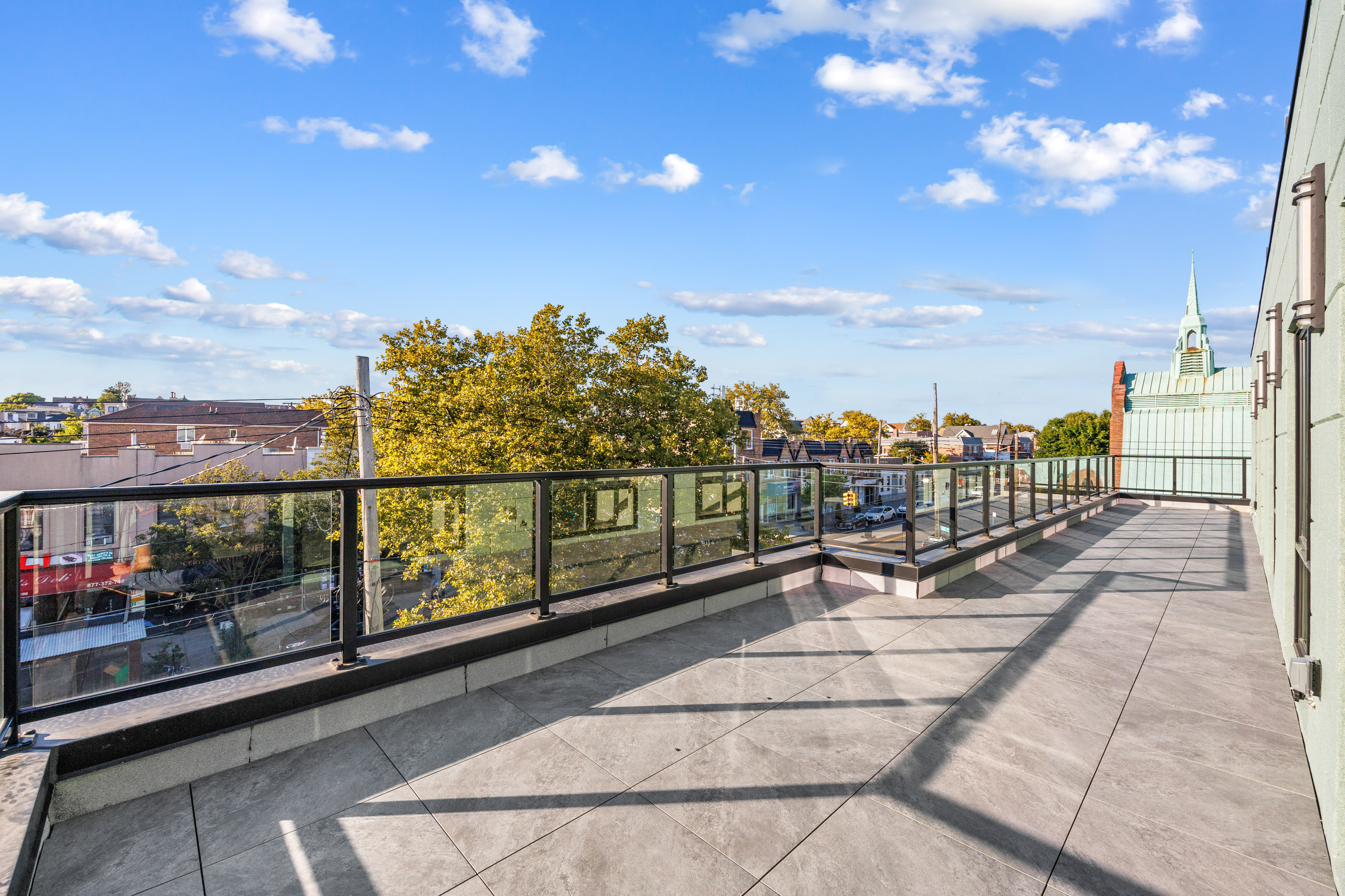 Private balcony with glass railing and neighborhood views