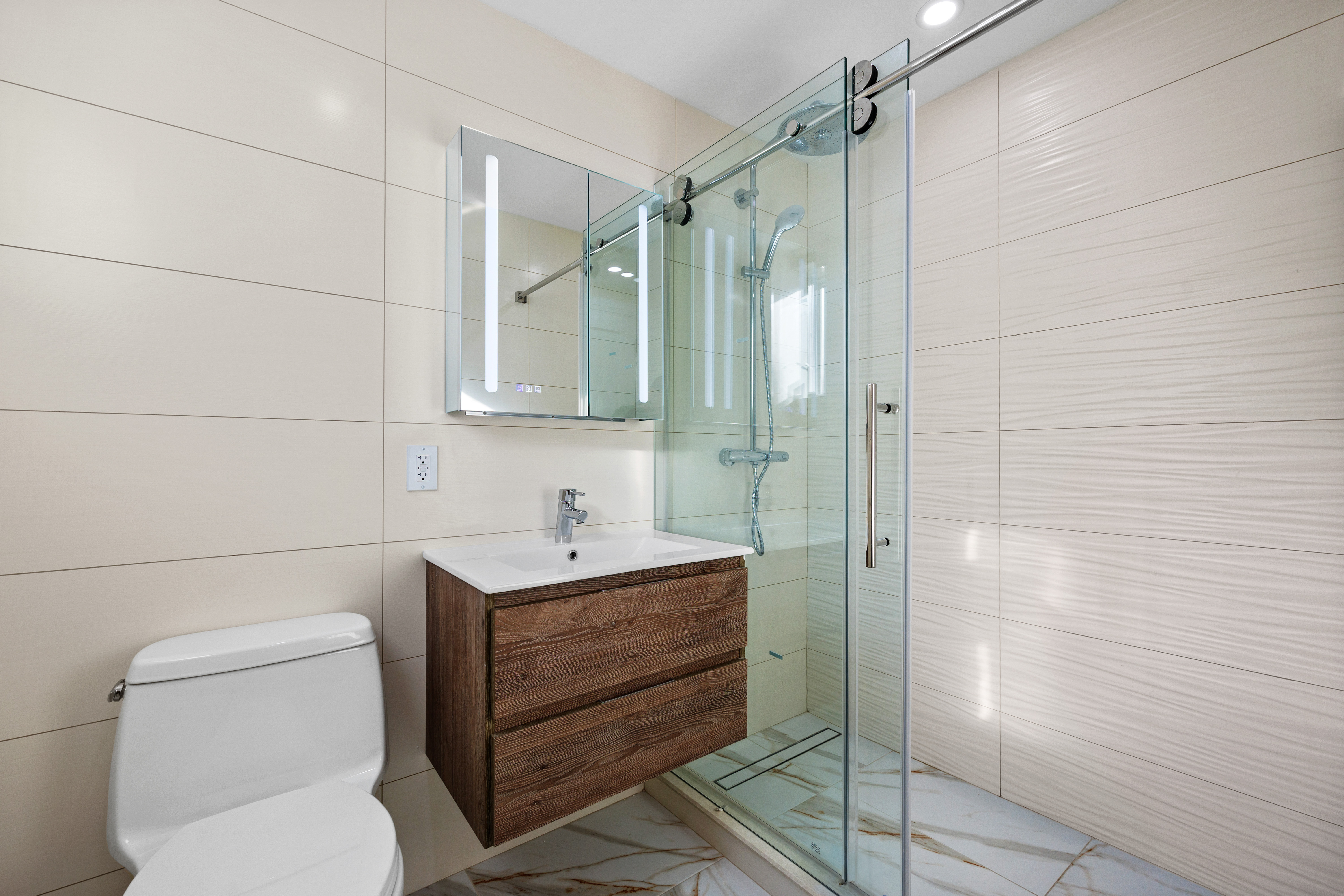 Modern bathroom with glass shower and wood vanity