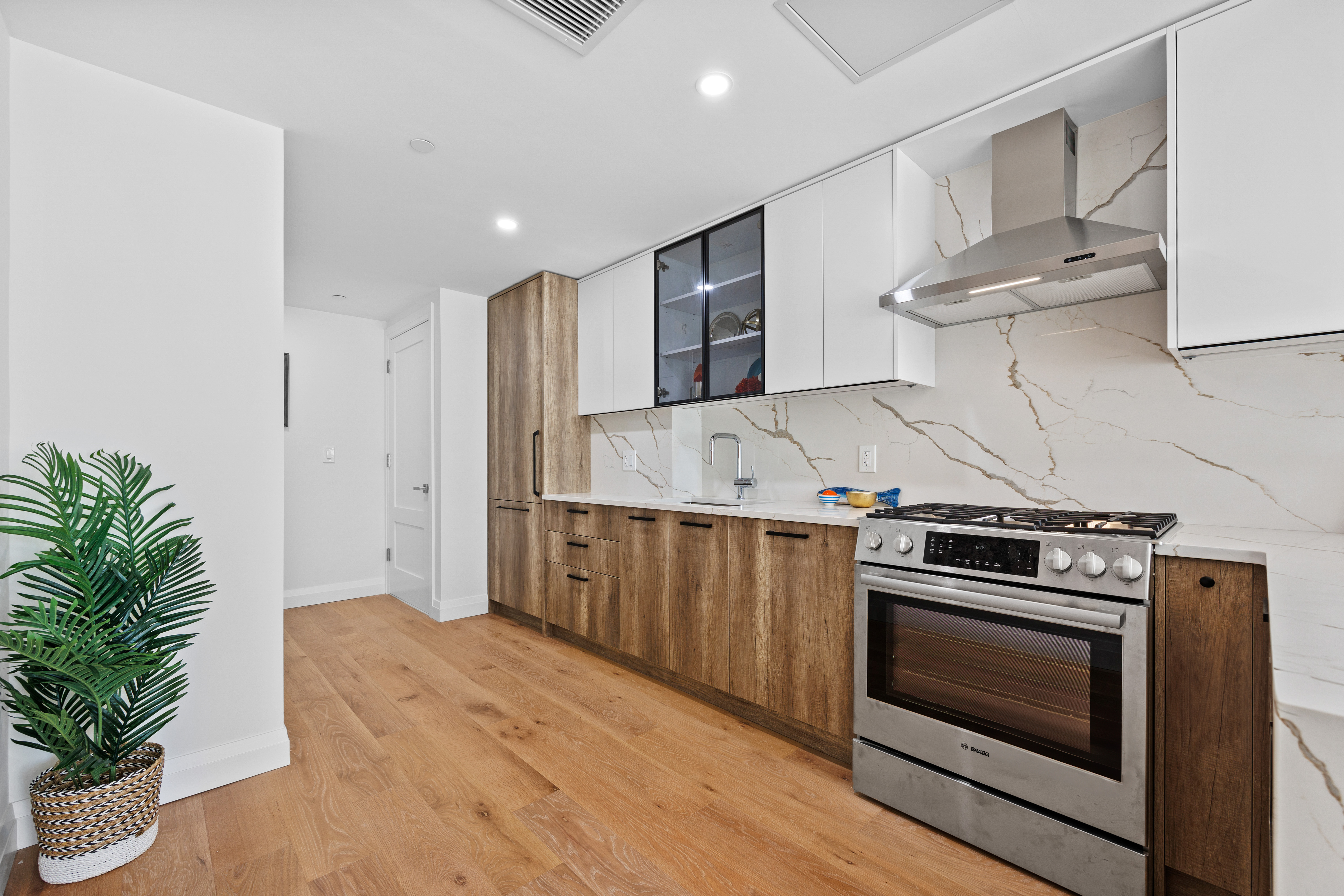 Kitchen with two-tone cabinets and marble backsplash