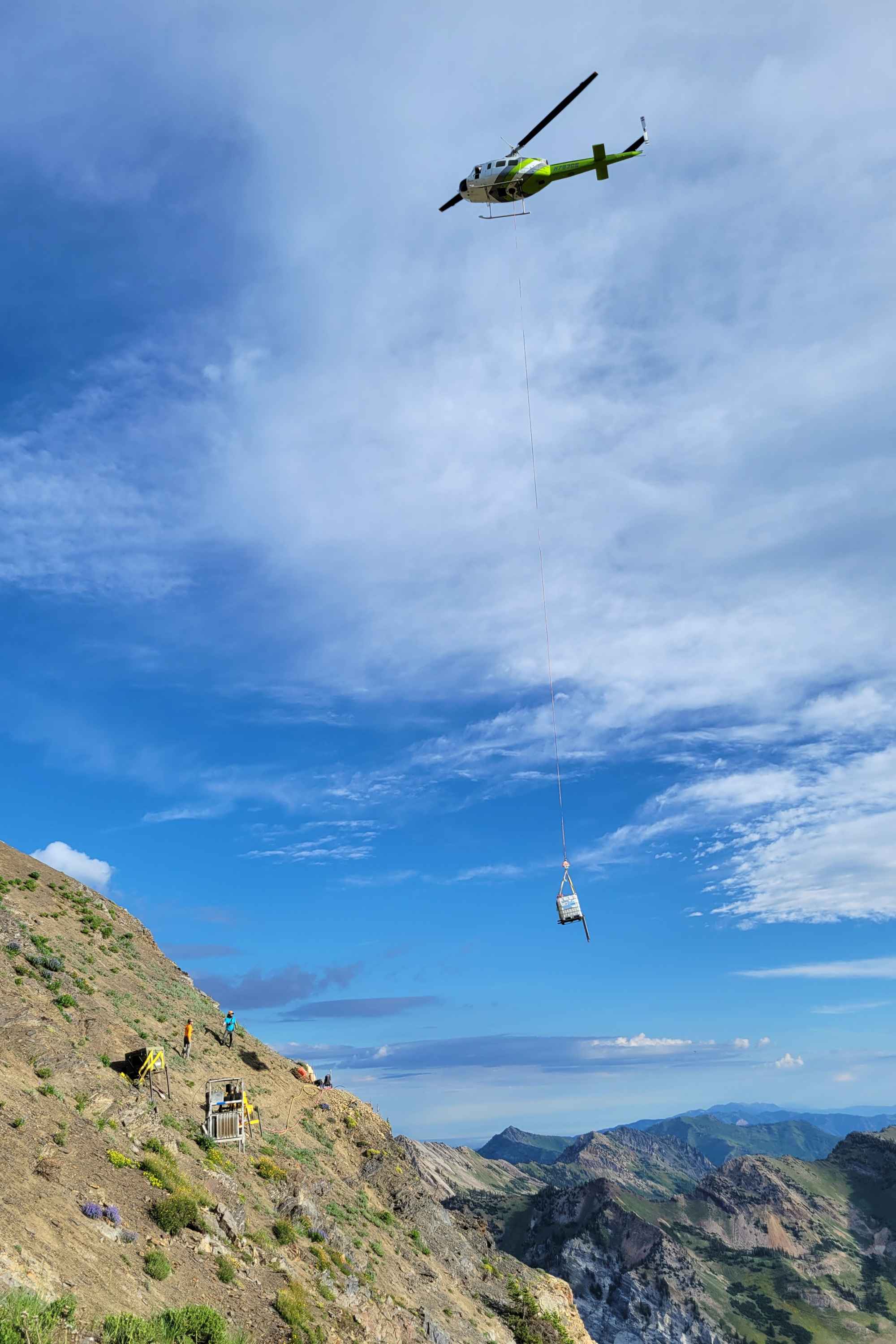 A helicopter flies equipment to the top of Mount Baldy