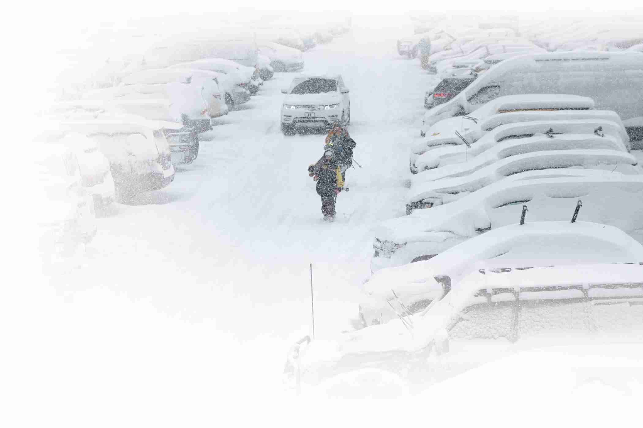 Alta skiers walk from the parking lot in a snowstorm at Alta Ski Area