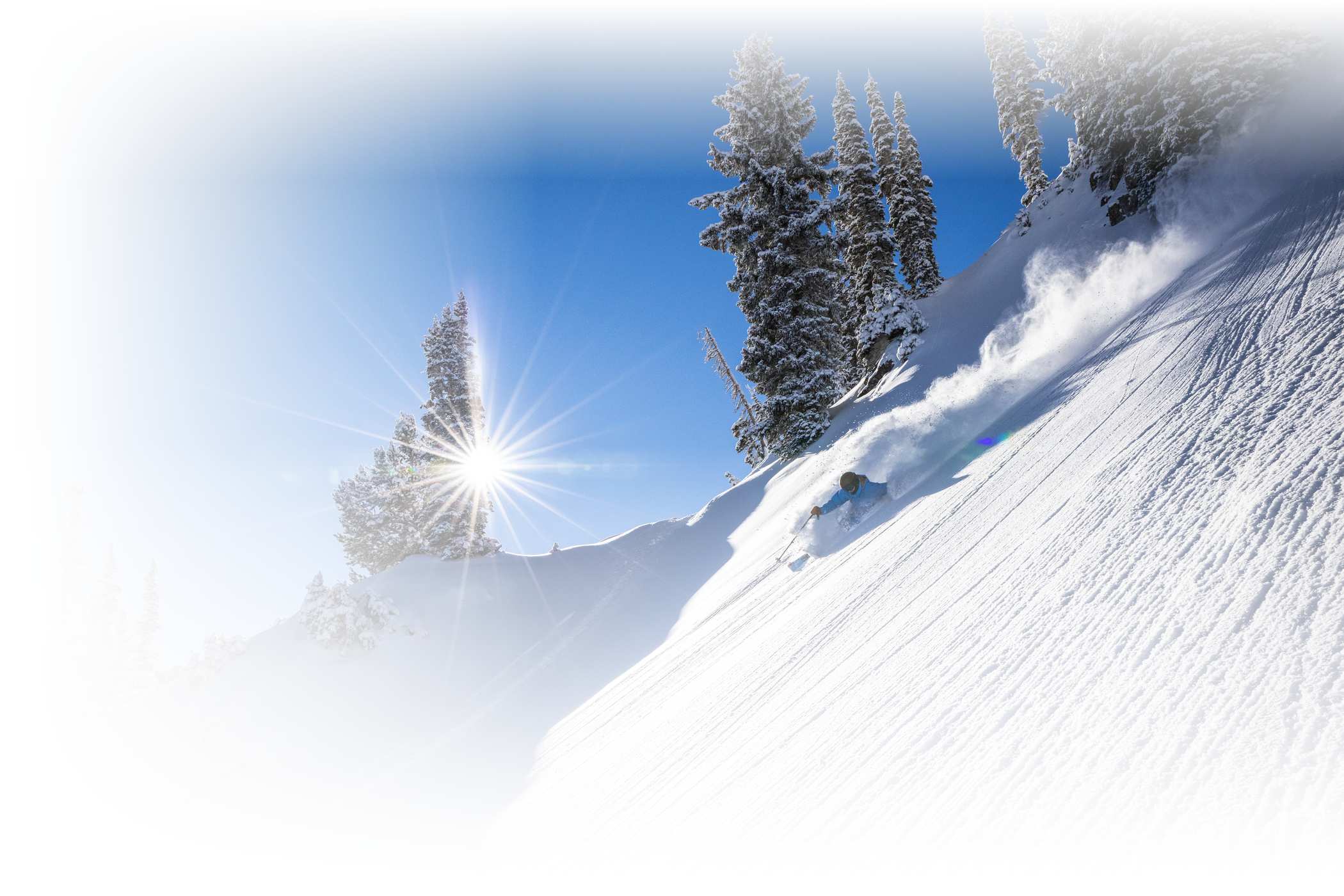 A skier skis deep powder on a bluebird day