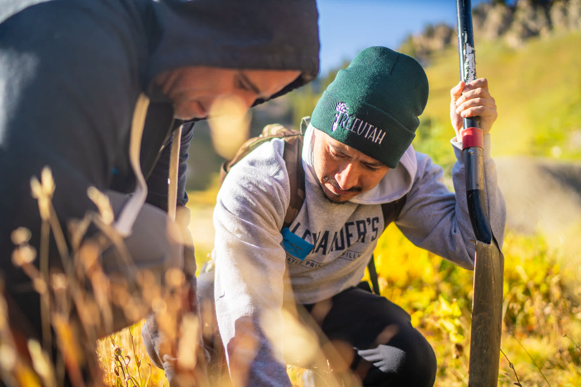 Two volunteers teaming up to carefully plant their seedlings 