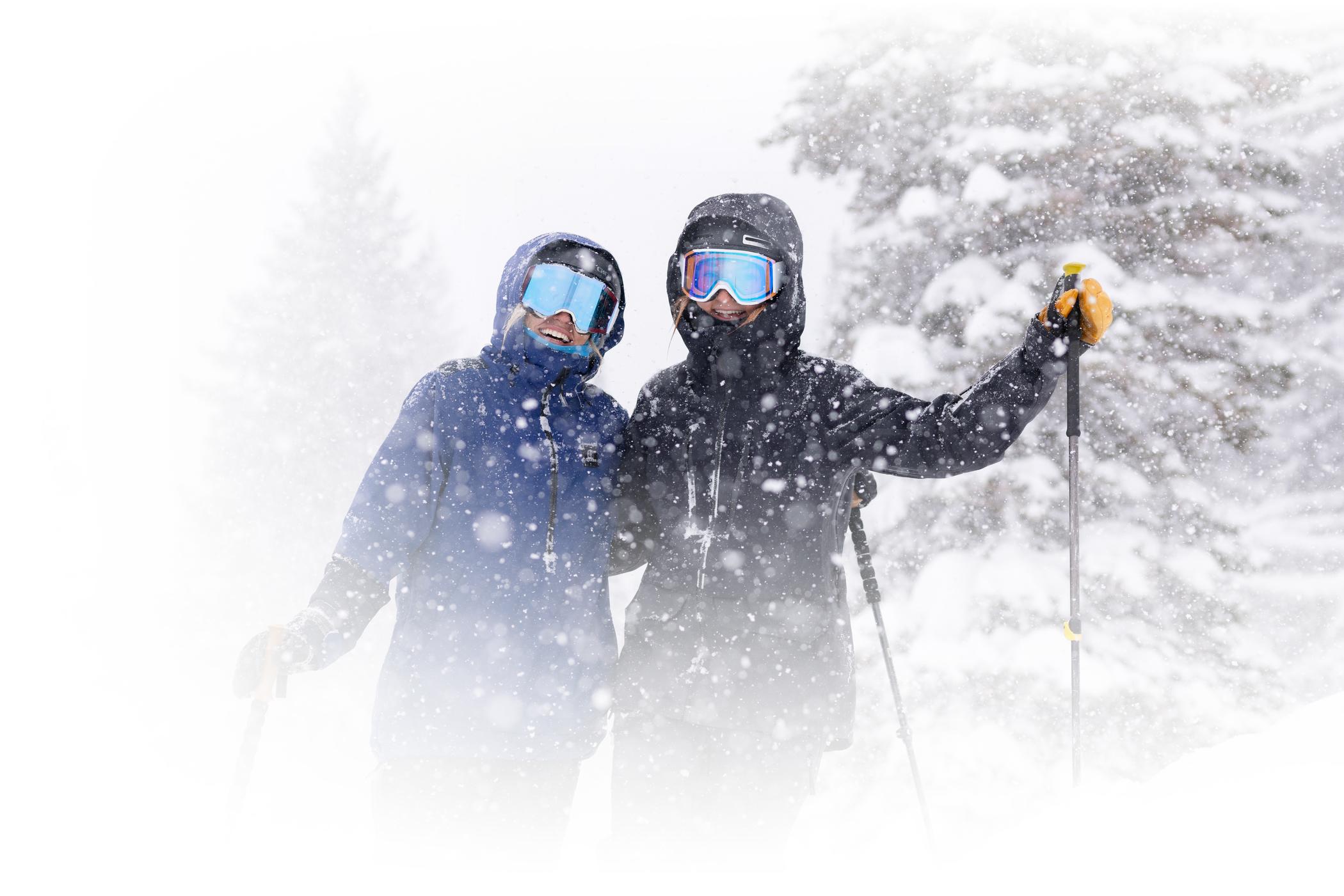 Two stoked skiers smile on a snowy day at Alta Ski Area