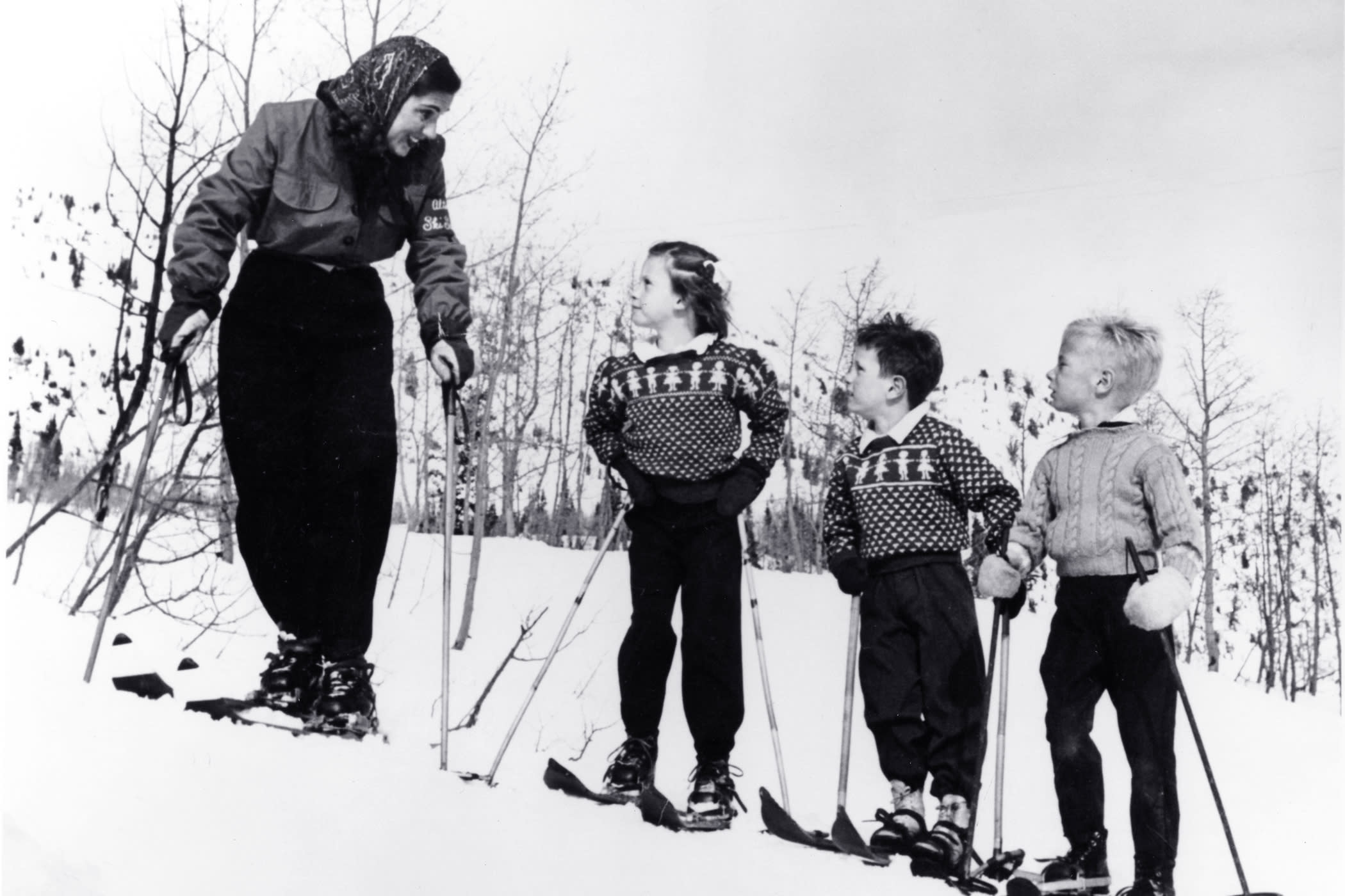 Lois Engen guides a class of young children in ski school
