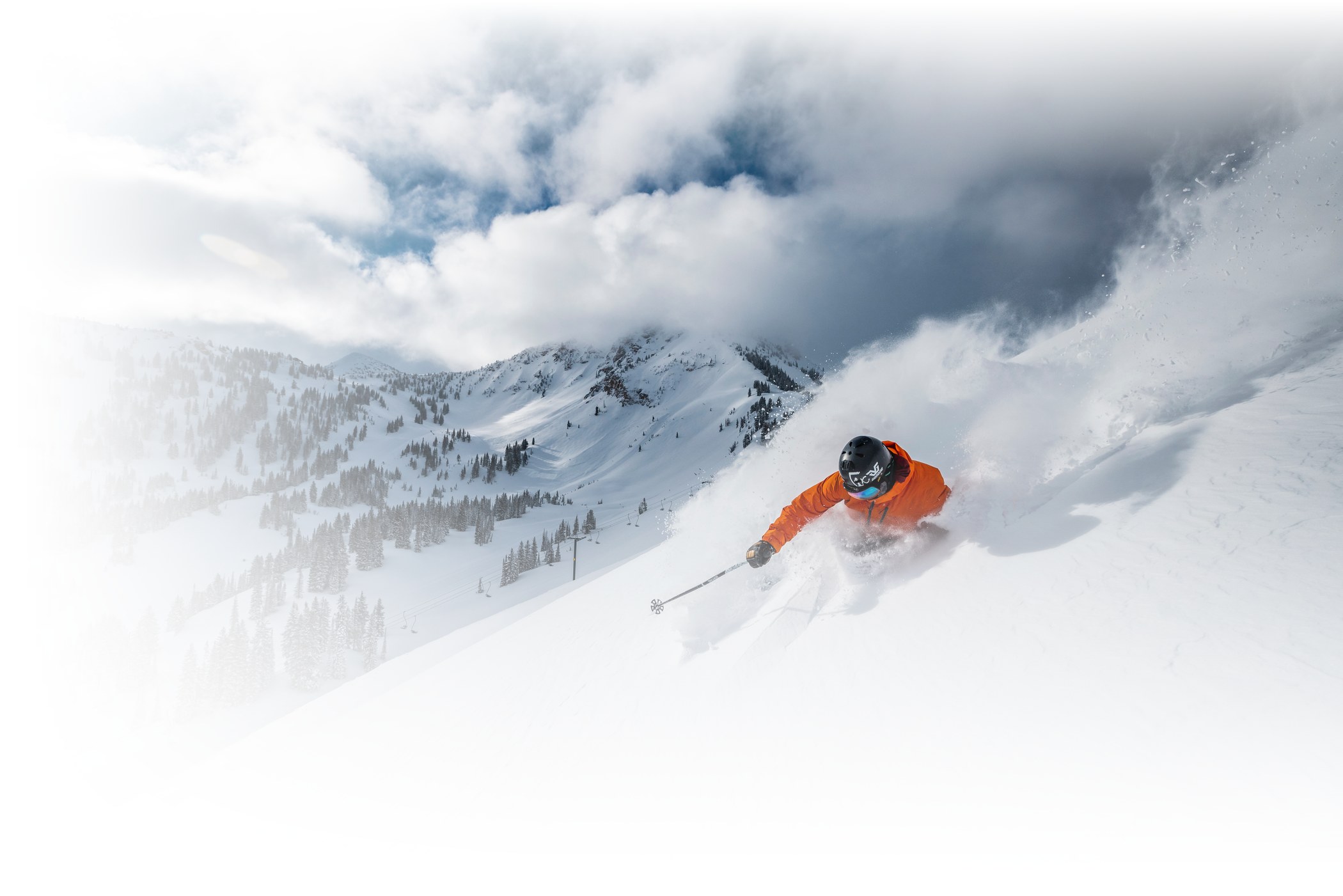 A skier skis deep powder on a sunny day at Alta Ski Area