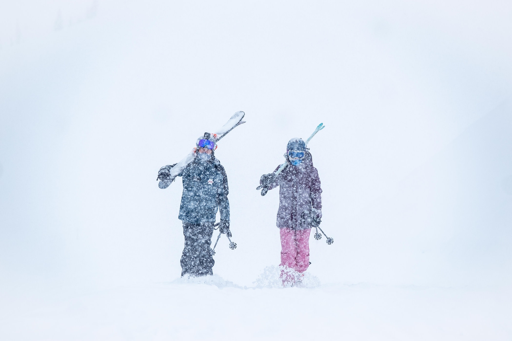 Skiers walking through a Saturday snowstorm at Alta