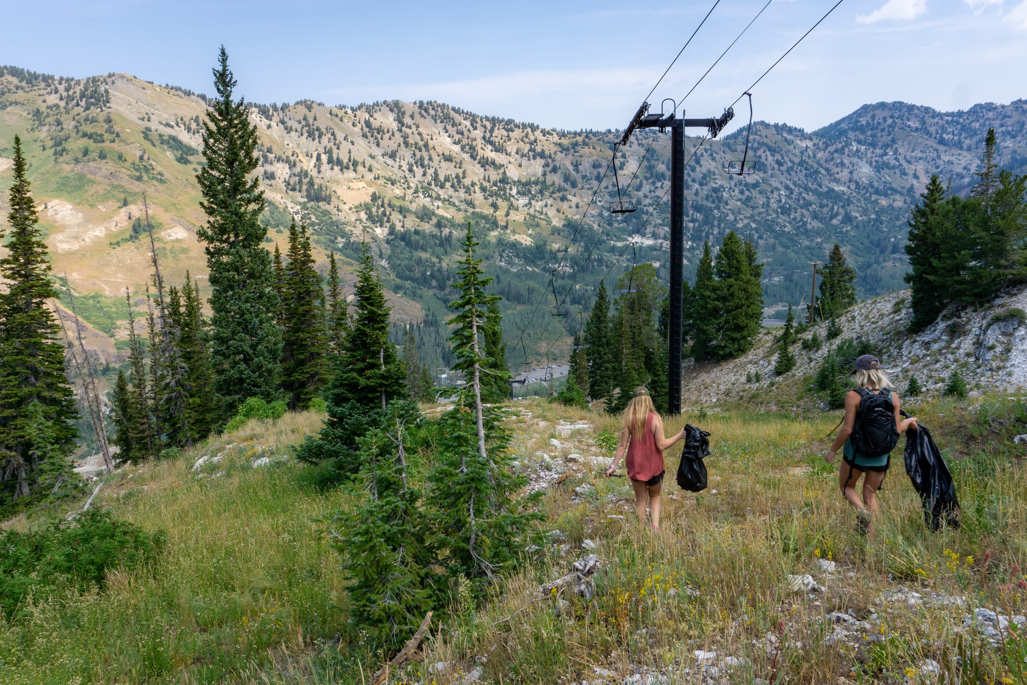 Two volunteers search for trash under the Wildcat lift