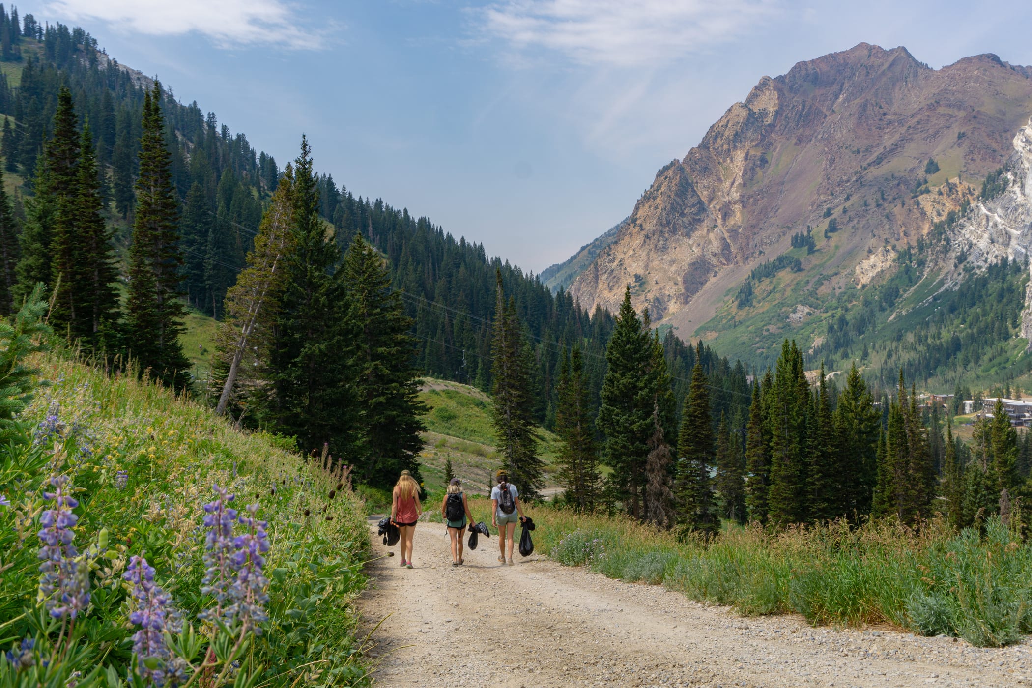 Volunteers with trash bags make their way back down to the Wildcat base area