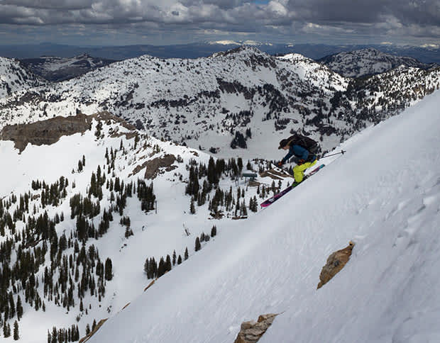 Skier with backpack skiing a steep slope