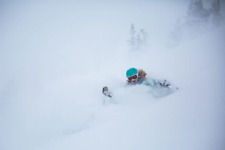 Madison Ostergren enjoys skiing deep powder by herself in a white-out