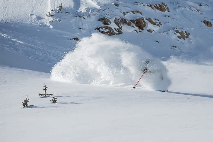 Skier hidden by cloud of snow, skiing deep fresh powder snow