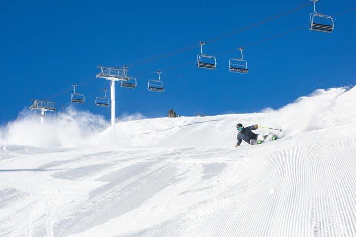 Skier making sharp turn on streep groomed slope