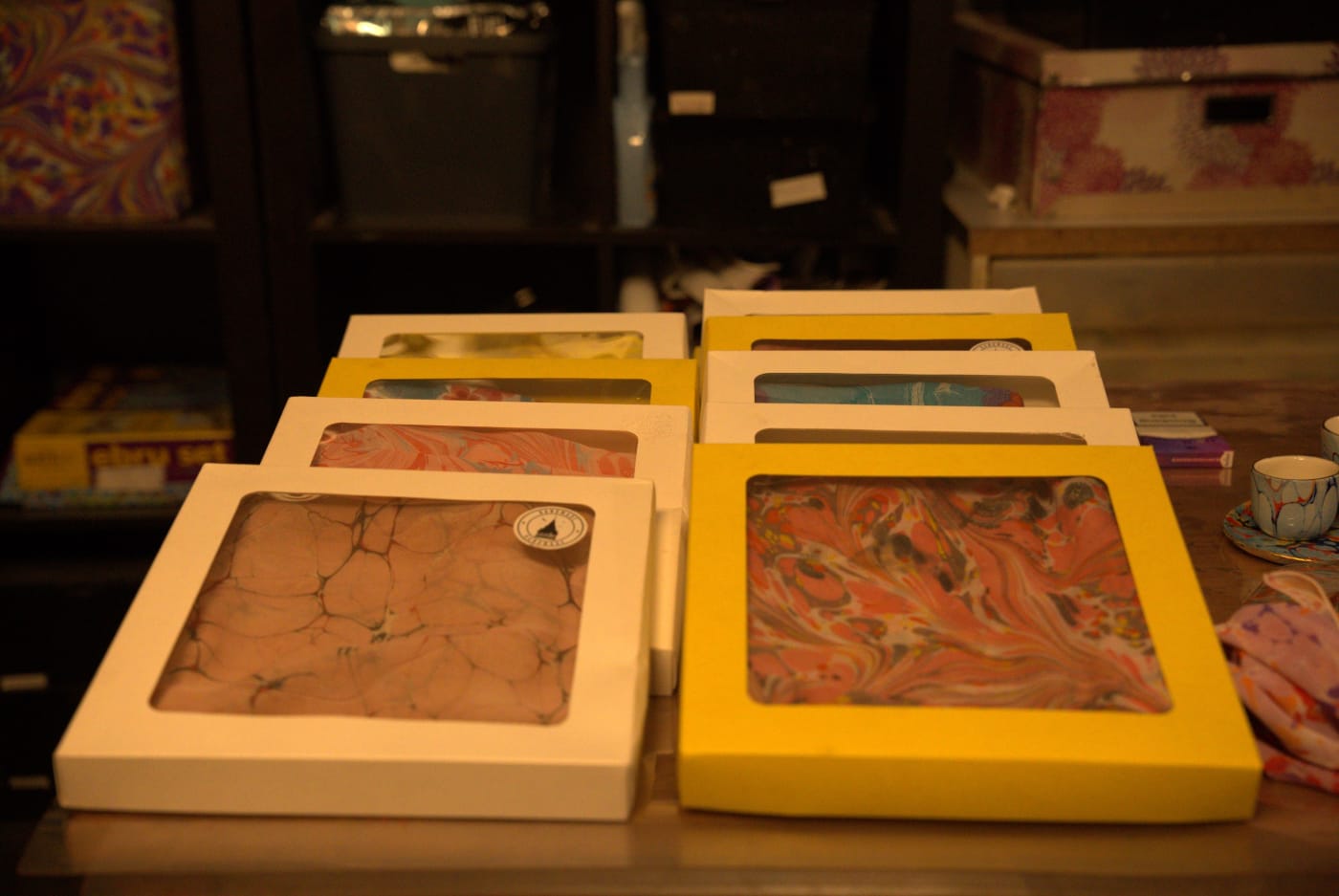 Finished marbled papers in white and yellow boxes on the table