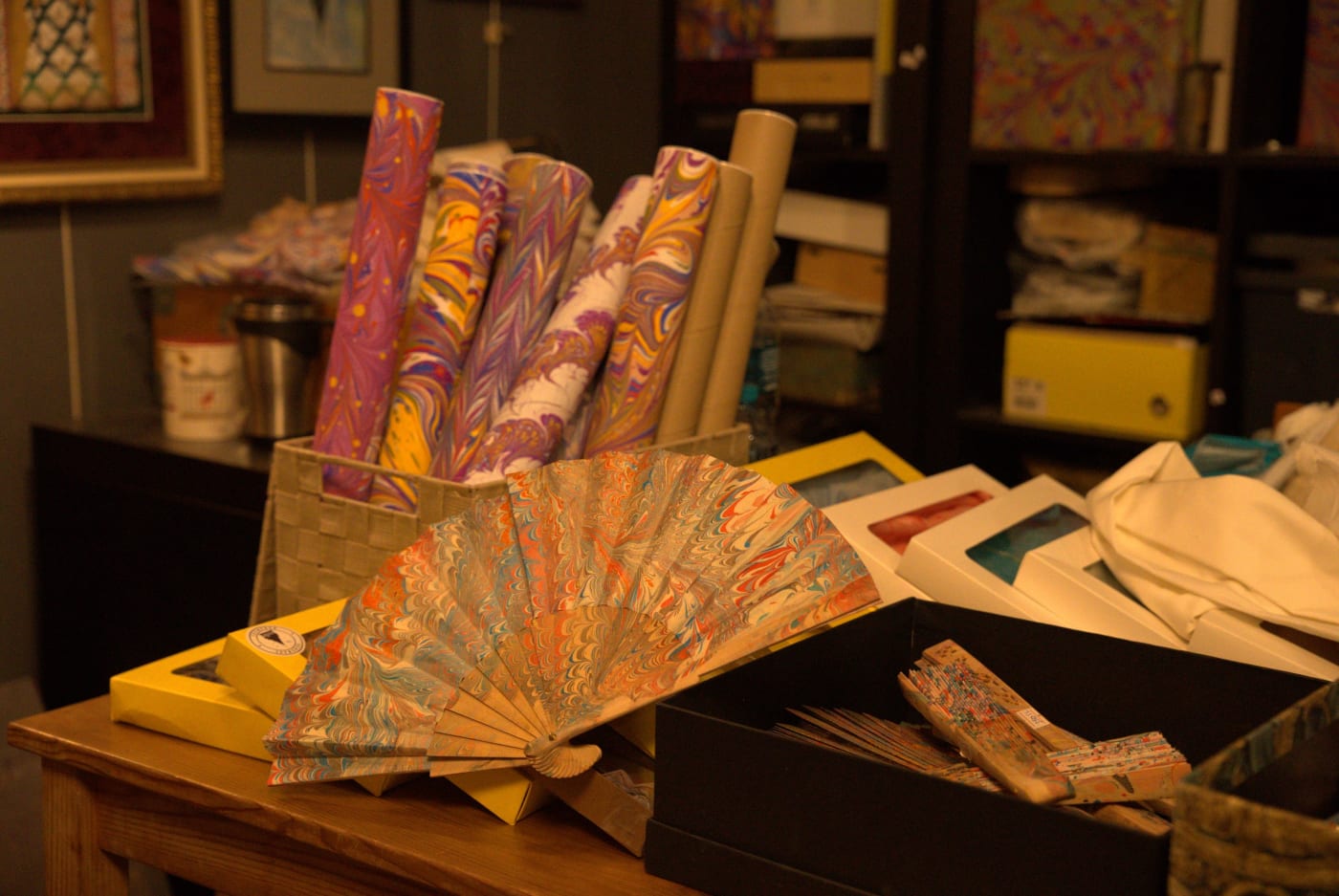 Rolls of marbled paper and a marbled fan on the atelier table