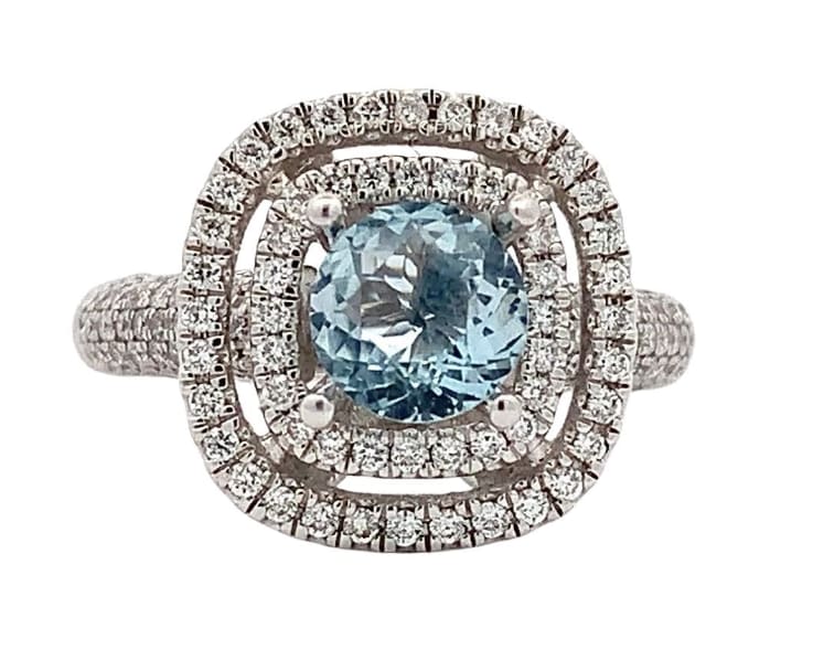 Discover the allure of this stunning blue topaz ring, featuring a captivating center stone surrounded by a halo of sparkling diamonds.