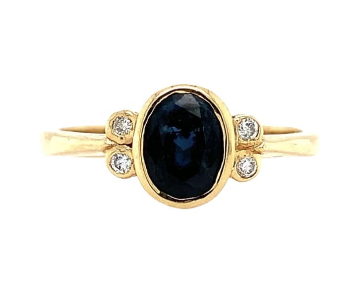 This beautiful ring features a stunning 0.80ct sapphire diamond in a solitaire setting, crafted with 18ct yellow gold. The ring is further adorned with two additional sapphire and diamond gemstones, making it the perfect eternity or engagement ring for any occasion. The blue colour of the main stone is complemented by the excellent cut grade and very slight inclusion of the diamonds, ensuring maximum brilliance and sparkle. 0.80ct Sapphire diamond engagement ring in 18k yellow gold. Oval blue sapphire with diamond in 18k yellow gold. Oval deep blue colour oval cut natural untreated gemstone total weight 0.70ct. Diamonds 0.10ct total weight G colour SI1 clarity. The ring can be resized Hallmarked Box and valuation included. The ring is available in size N and comes with certification from a valuation. The Sapphire Engagement Ring brand is renowned for its high-quality jewellery, and this piece is no exception. Whether you're looking for a ring to cherish for a lifetime or to give as a special gift, this stunning solitaire ring is sure to impress.