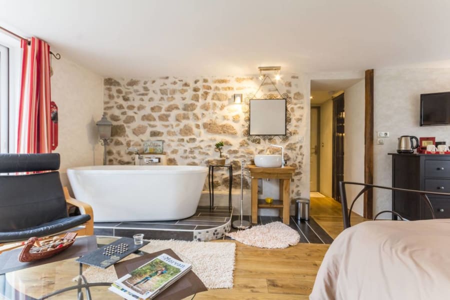 Baignoire îlot face au mur de pierres
