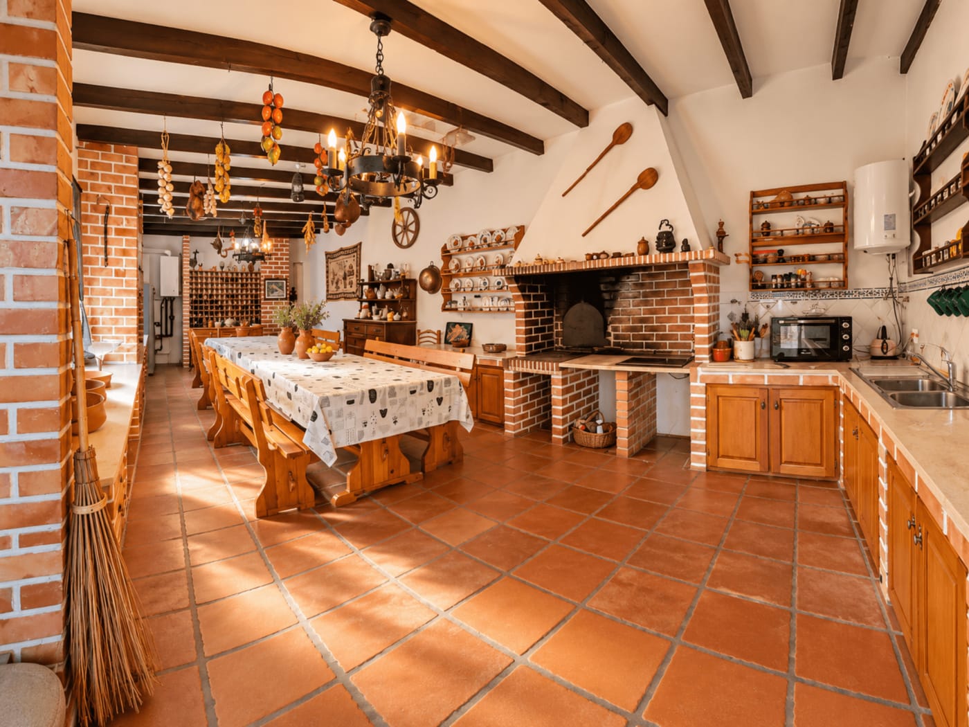 Cozinha comum da Vila Louro com lareira de tijolo e móveis de madeira