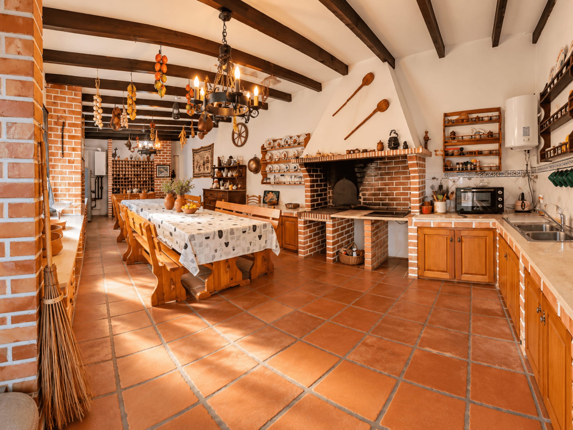 Cozinha comum da Vila Louro com lareira de tijolo e móveis de madeira