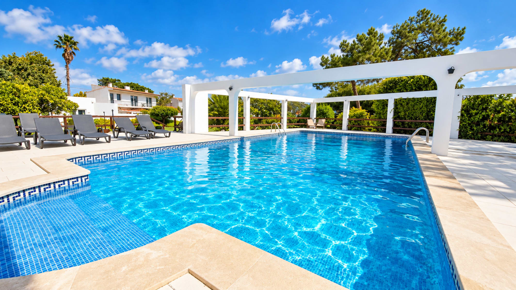 Piscina da Vila Louro com pérgola branca e espreguiçadeiras, em Santa Cruz