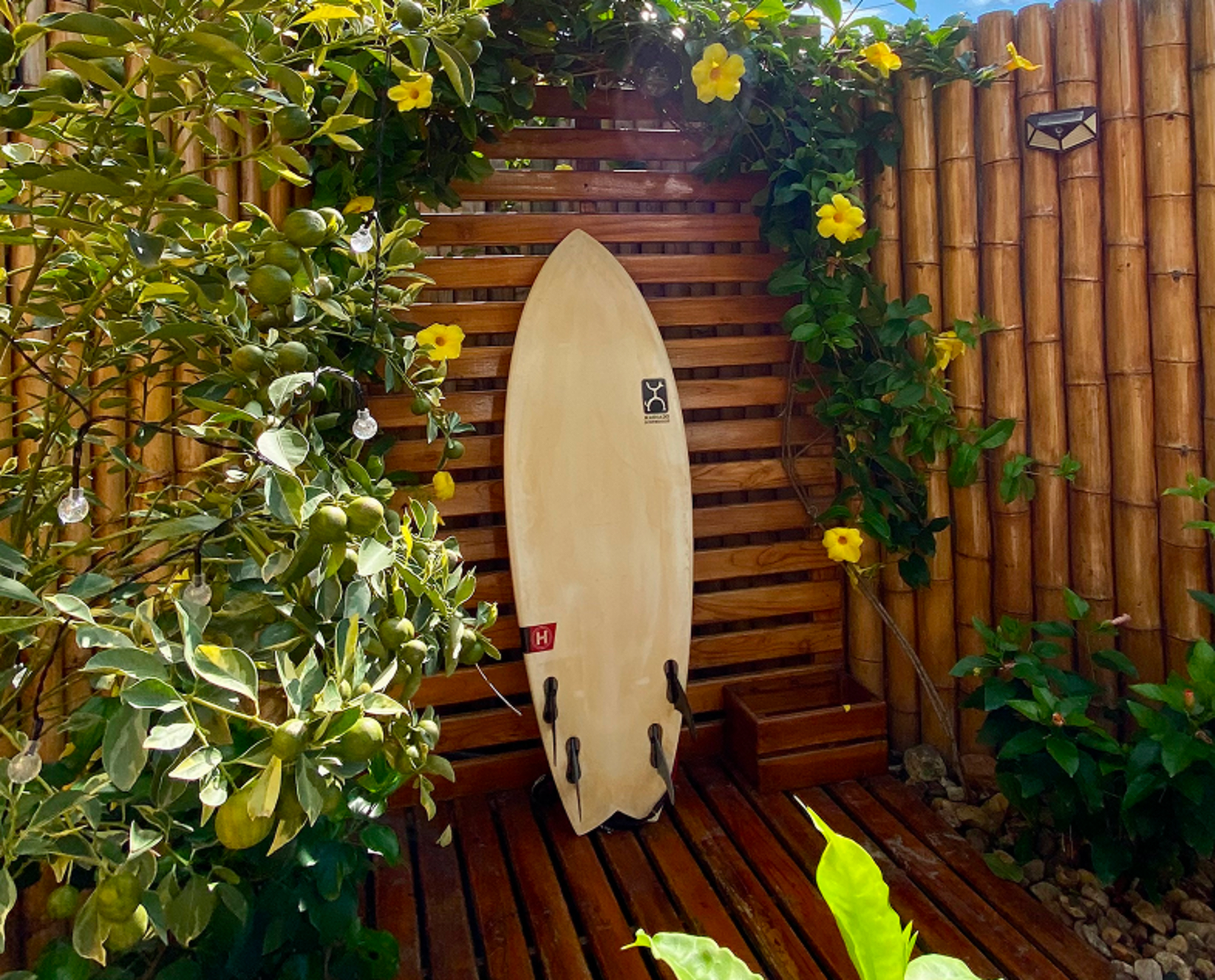 Surfboard leaning against a bamboo wall