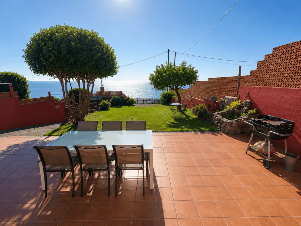 Terraza y jardín de Villa Santa Rita con vistas al mar en Oia