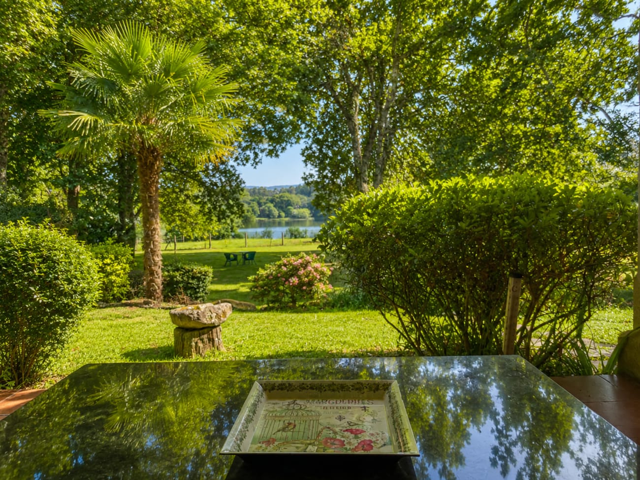 Amplio jardín con césped y árboles frondosos de As Landras