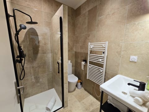 Salle de bains privative avec douche italienne, sèche-serviettes et vasque