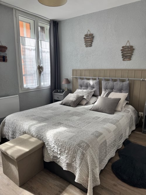 Chambre moderne au Paillot de Montabert à Troyes avec lit double, tête de lit grise et vue sur la ville