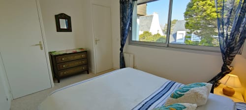 Chambre lumineuse à Mer et Maisons à La Trinité sur Mer avec vue sur la mer, lit blanc, commode en bois et grandes fenêtres