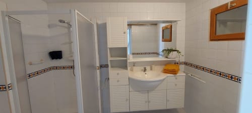 Modern bathroom in Orchids cottage at Les Gites de Campardon with shower, sink vanity, and decorative tile accents