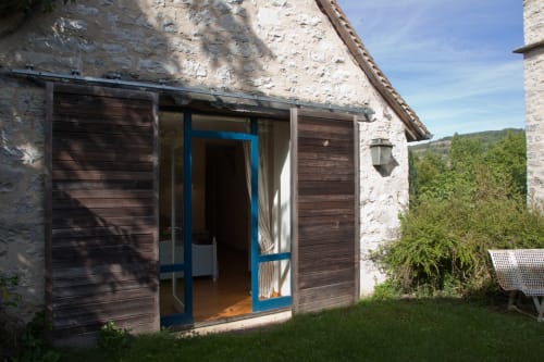 Entrée de la grange d'Andressac avec porte bleue aux Chambres d'hôtes Les Pratges à Figeac, France