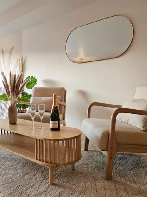 Salon moderne du gîte Saint Valéry-en-Caux avec meubles en bois, bouteille de champagne, miroir vue mer et ambiance côtière