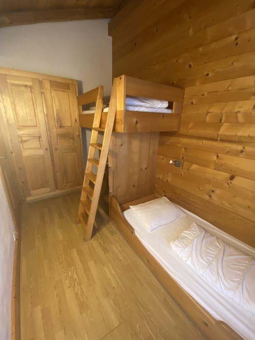 Chambre avec lit superposé en bois, échelle et draps blancs à La Ferme des Georgières à Notre-Dame-de-Bellecombe