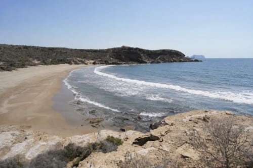 Sandy beach cove with turquoise Mediterranean waters and rocky headlands at Apartamentos El Calón Playa, Cuevas del Almanzora