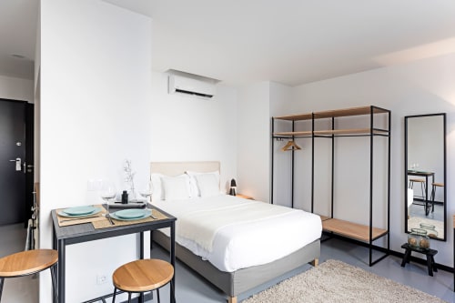 Estúdio moderno no Porto com cama, mesa de jantar, kitchenette e guarda-roupa com estrutura metálica em design contemporâneo