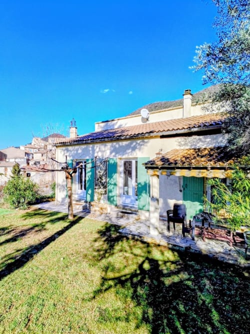 Pet-friendly villa in Venterol, South France, with cream walls, green shutters, enclosed garden, and mountain views under