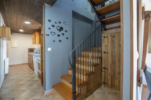 Moderno interior de apartamento con escalera de madera, pared azul destacada, cocina abierta y decoraciones de corazón en la montaña de Montgat