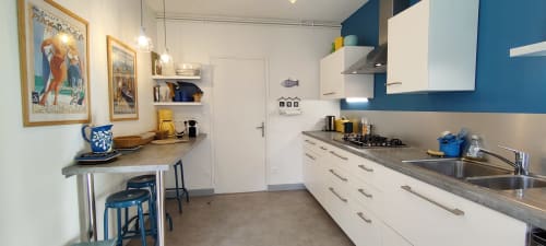 Cuisine moderne de la villa Mer et Maisons à La Trinité-sur-Mer avec mobilier blanc, touches bleues et comptoir