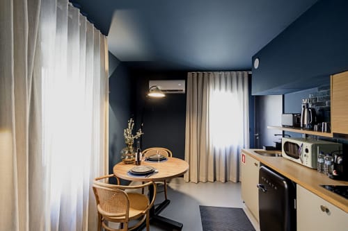 Cozinha e sala de jantar de estúdio duplex moderno no Benefit Collection Porto com kitchenette, mesa redonda em madeira e design contemporâneo